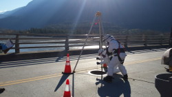 Workers prepare to enter this confined space below the roadway of a bridge